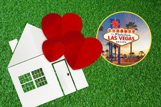 white paper cutout of a house and red hearts over artificial turf next to welcome to las vegas sign