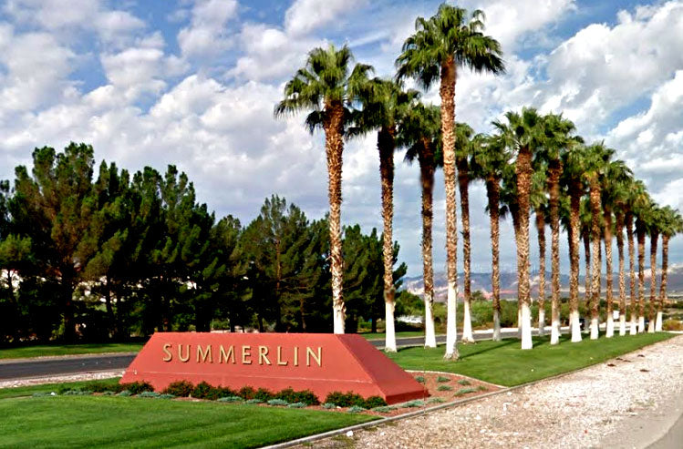 Row of palm trees in front of a 'Summerlin' sign with a clear sky.