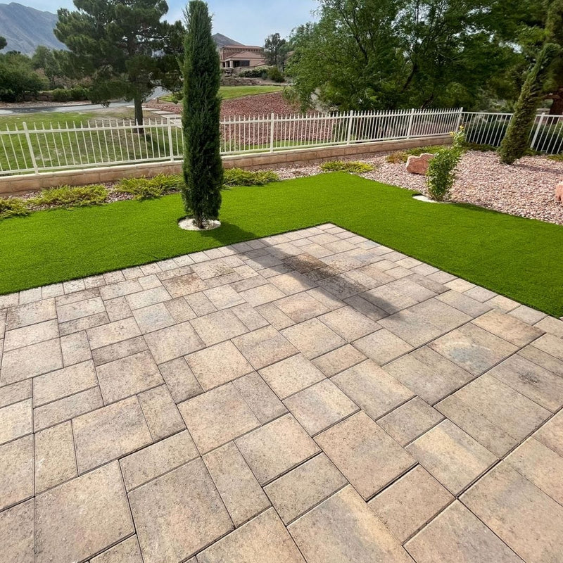 Paver courtyard plaza framed by cypress trees and artificial turf